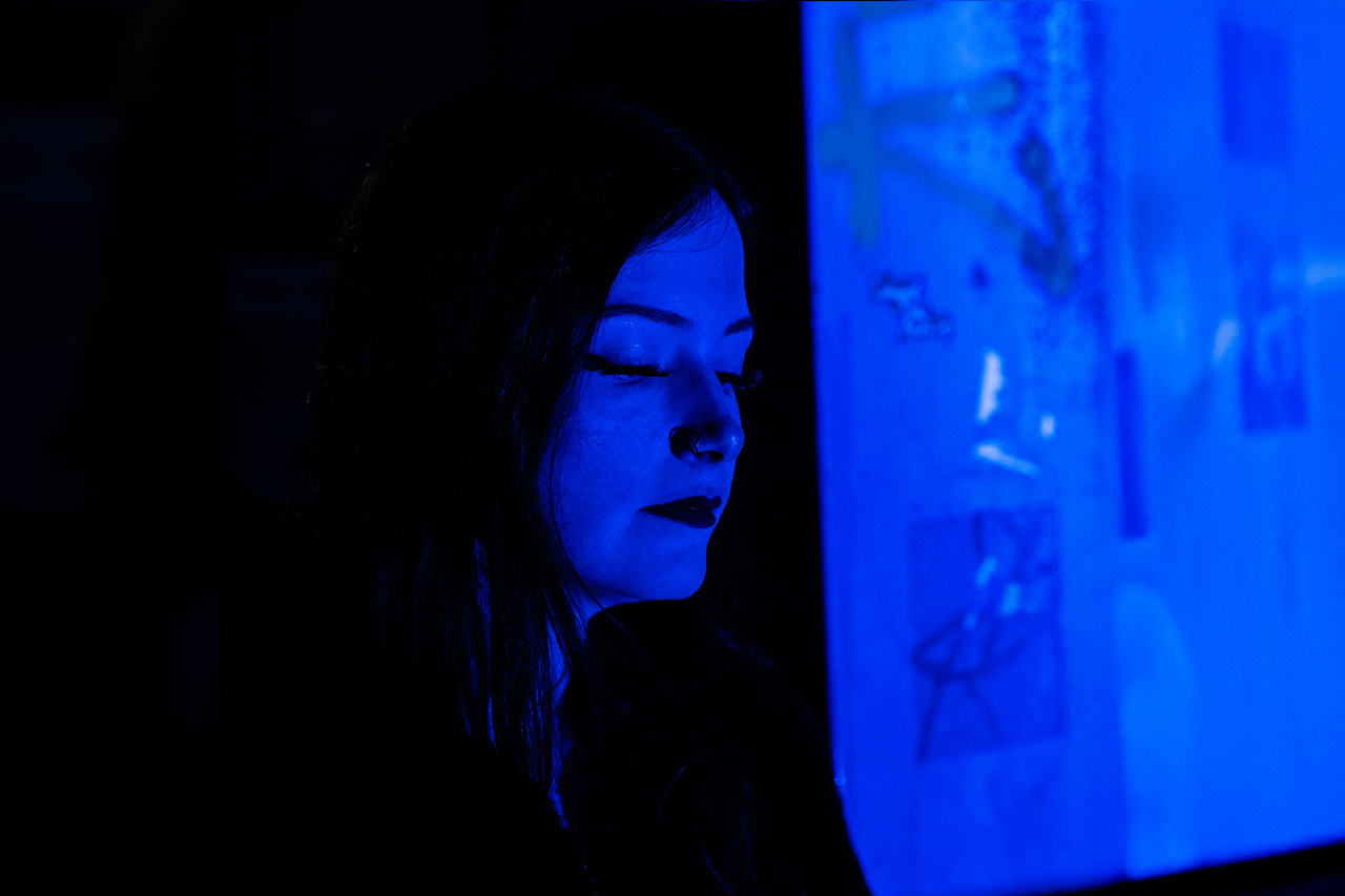 Karina Rose im blauen Licht, verträumt nach unten blickend