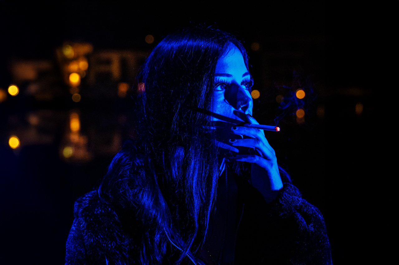 Karina Rose im blauen Licht, Zigarette glüht im Kontrast