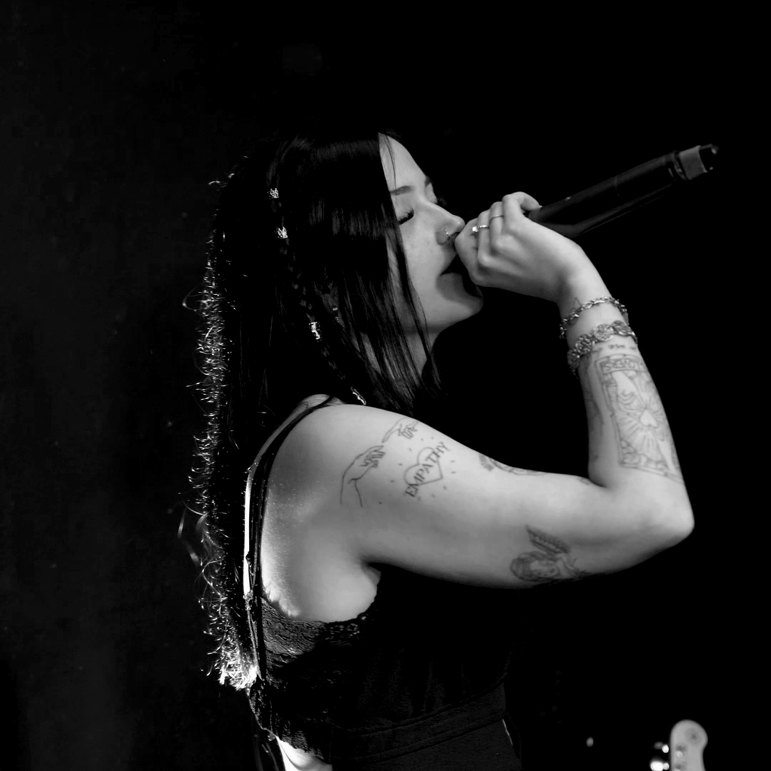 Karina Rose singt emotional mit geschlossenen Augen und Mikrofon in Schwarz-Weiß