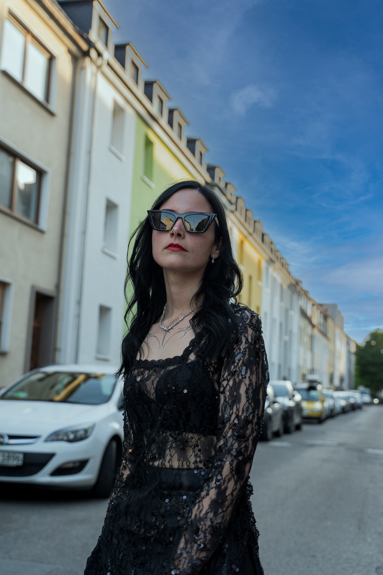 Karina Porträt mit Sonnenbrille auf der Straße vor blauem Himmel