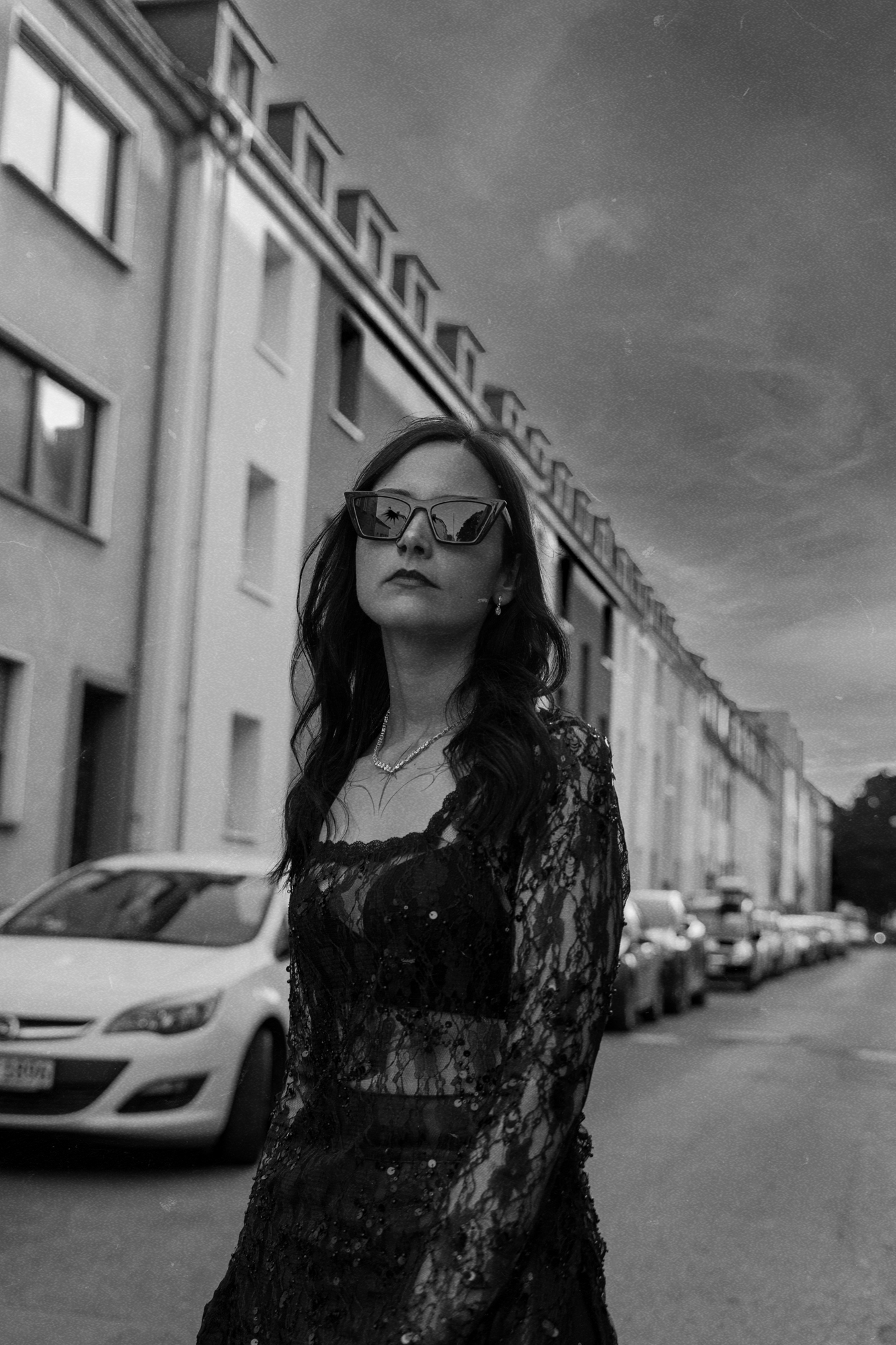 Schwarz-Weiß Porträt von Karina mit Sonnenbrille auf der Straße