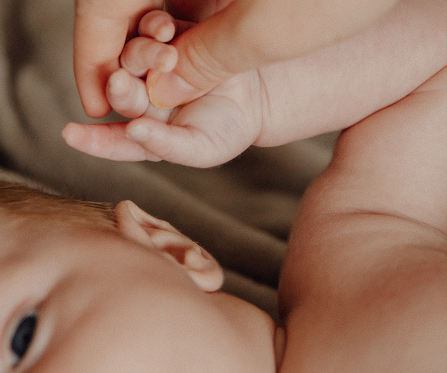 Babys Hand wird liebevoll von einer Frauenhand gehalten
